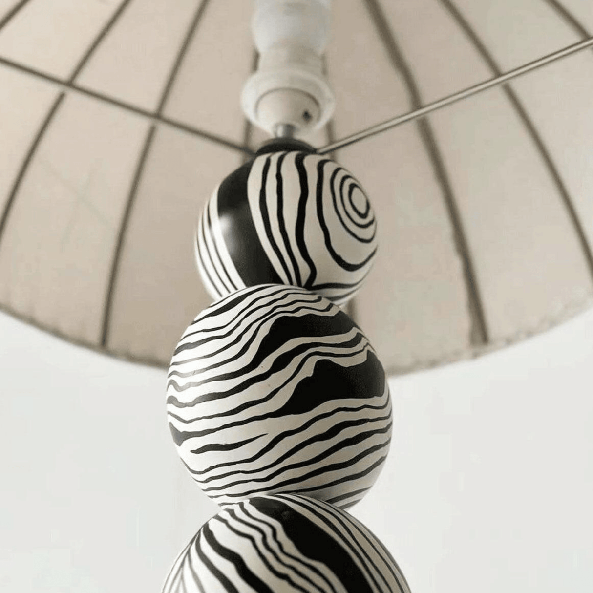 Decorative lamp with black and white striped design on a neutral background