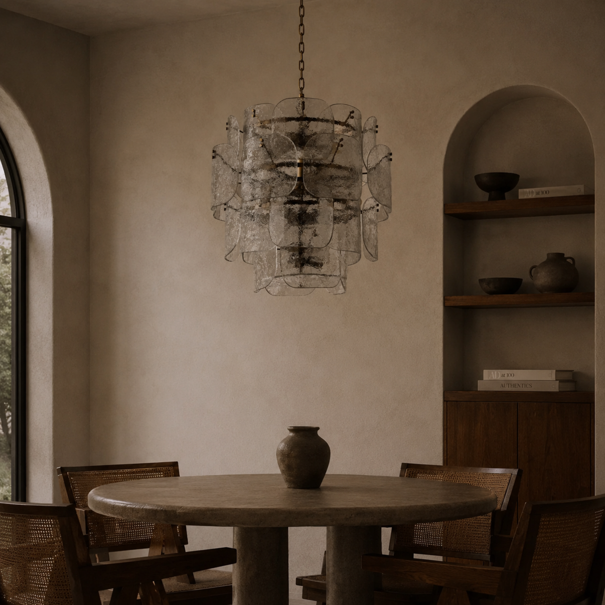 Dining room with a round table, chairs, and a modern chandelier.