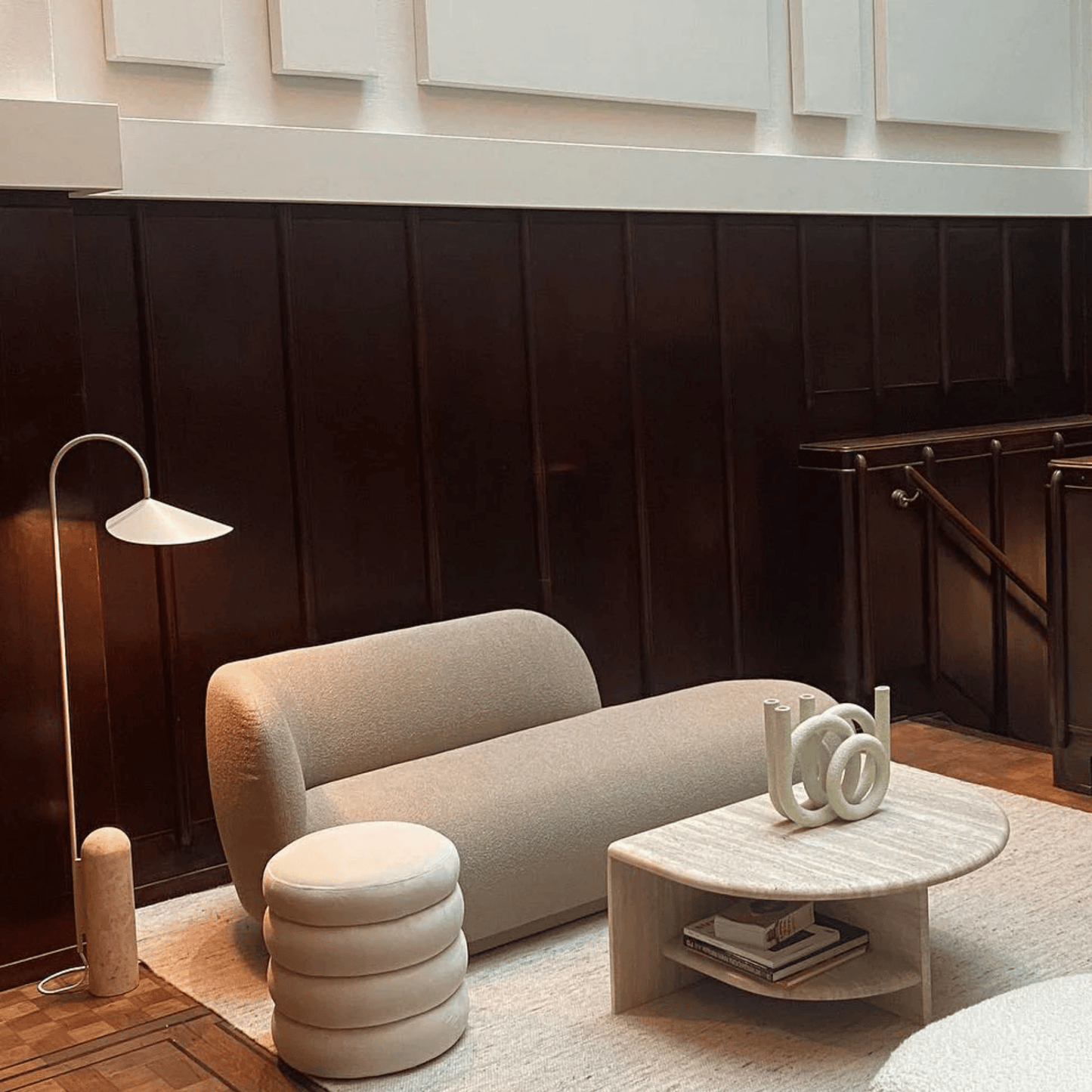 Modern living room with a beige sofa, coffee table, and decorative items.