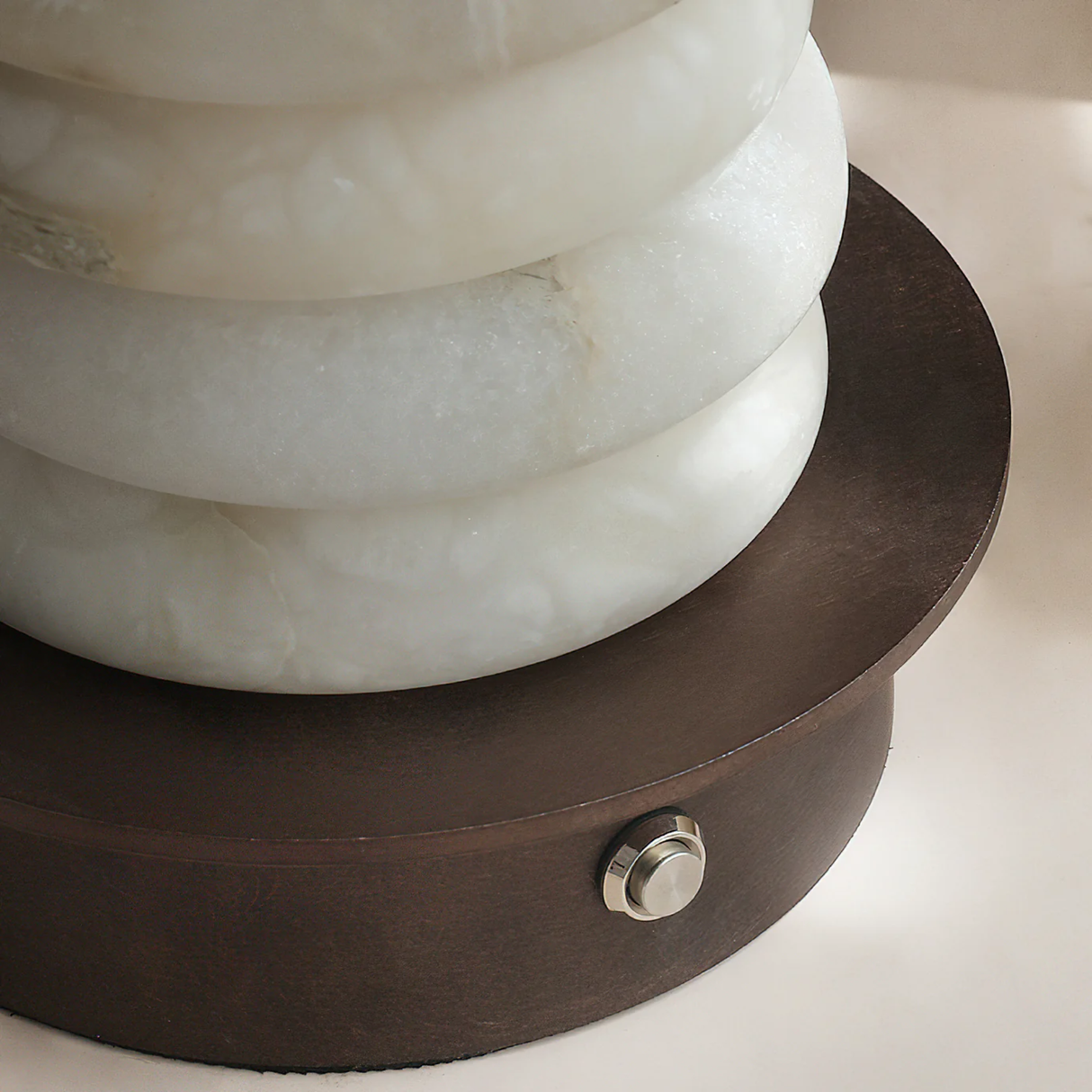 Decorative lamp with marble-like design and wooden base on a light background