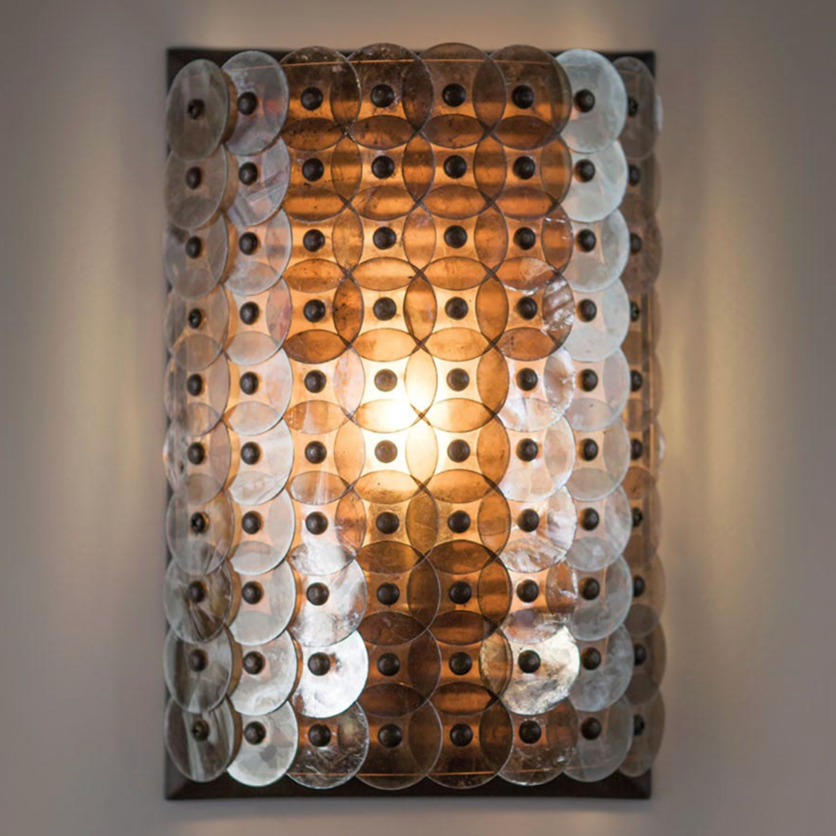 Decorative wall light with circular panels on a gray background