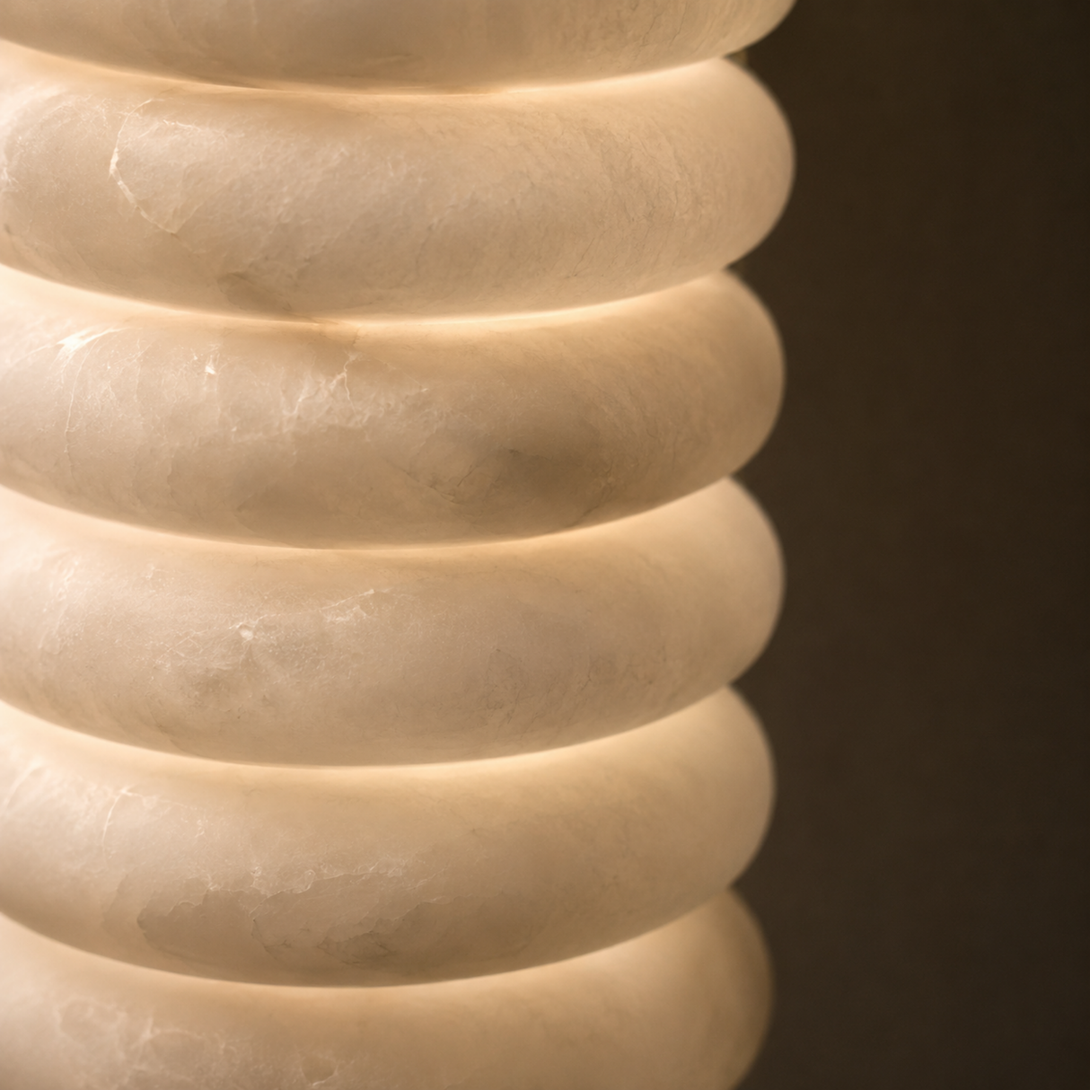Close-up of a textured beige vase against a dark background