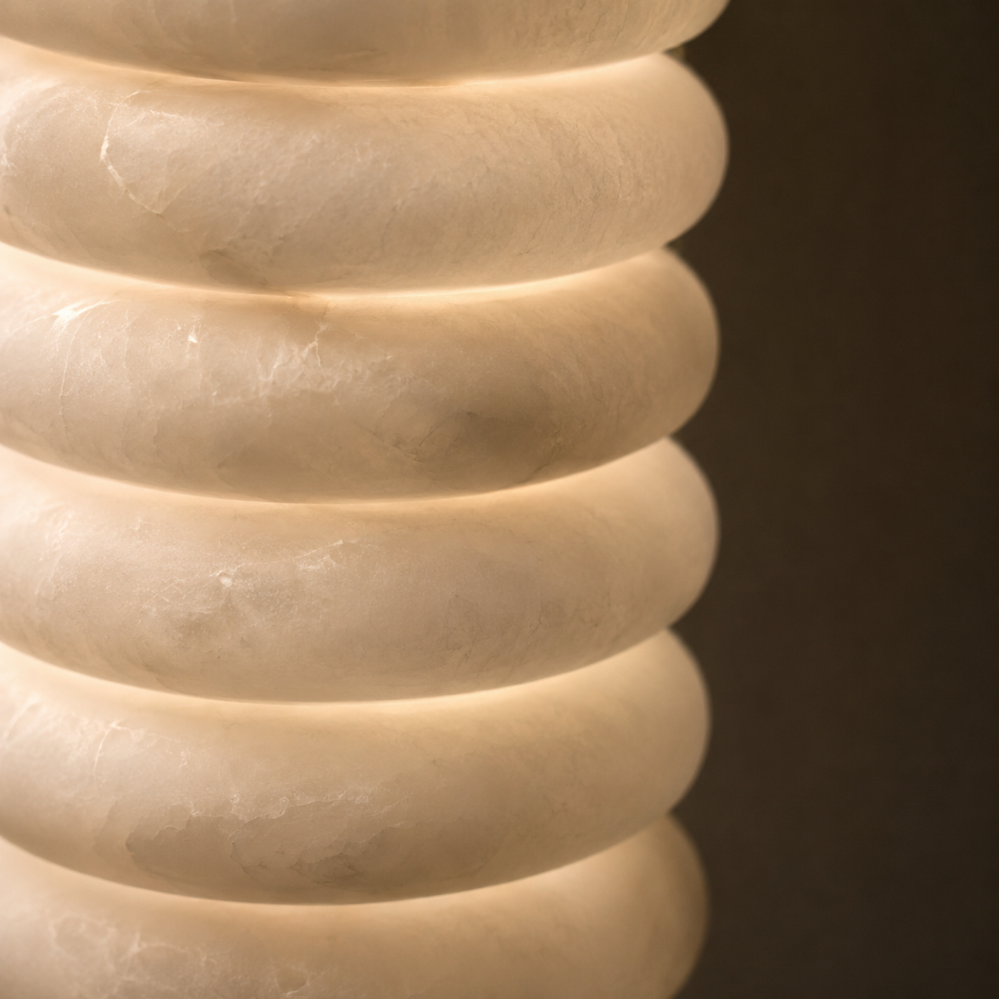 Close-up of a textured beige vase against a dark background