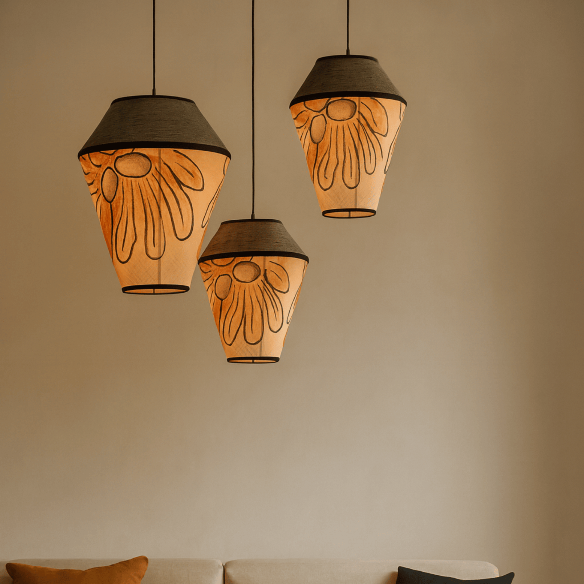 Three decorative pendant lights with floral patterns hanging against a beige wall.