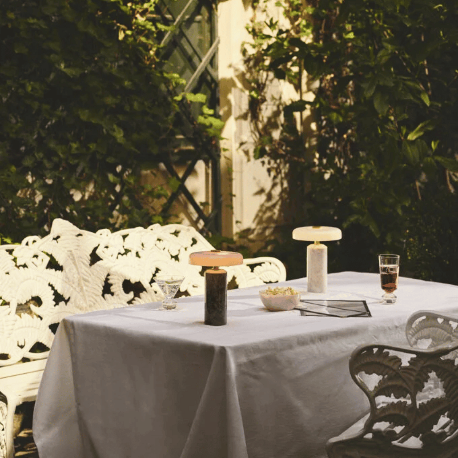 Outdoor setting with a table, chairs, and decorative items in a garden.