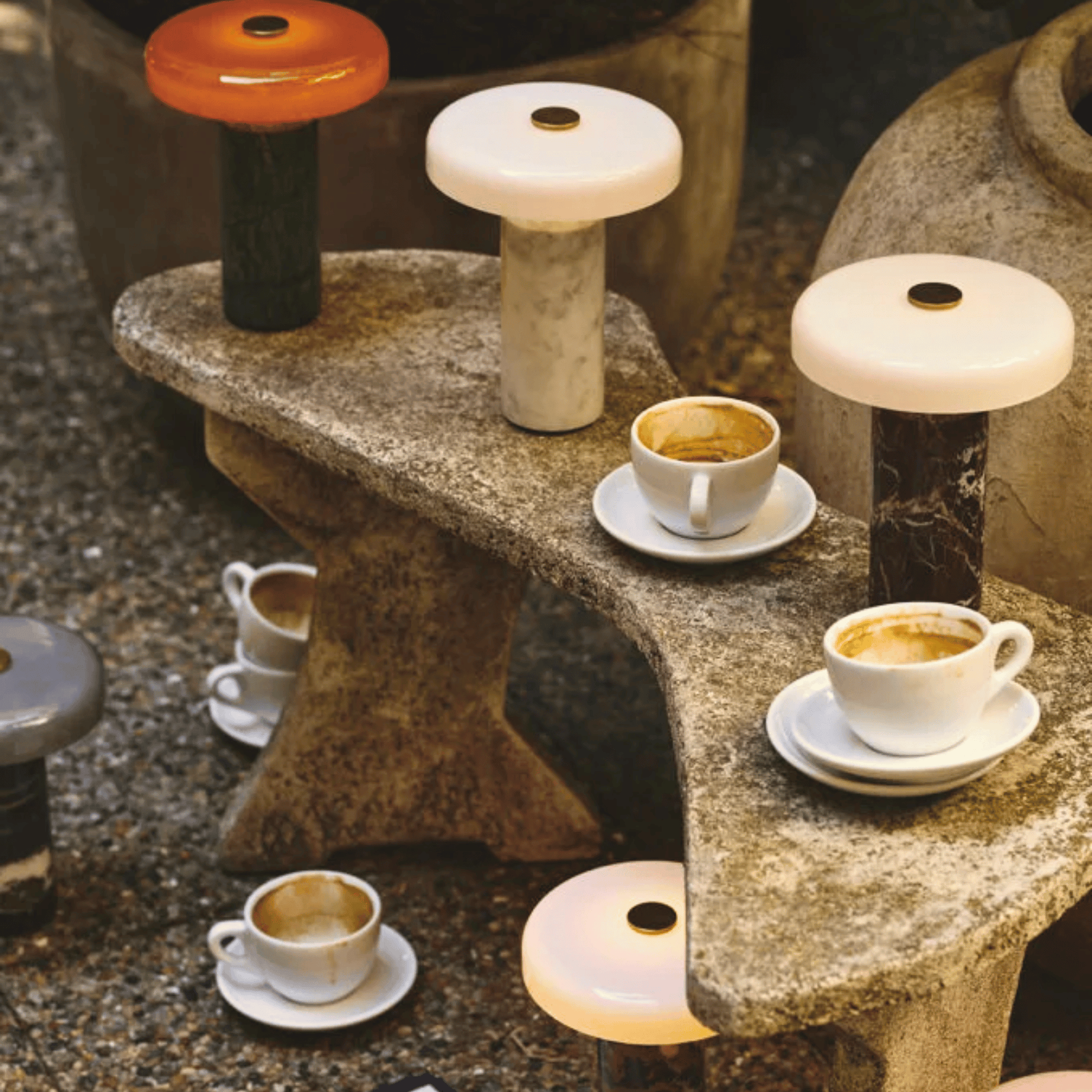Ceramic stools with unique designs on a stone surface with coffee cups.