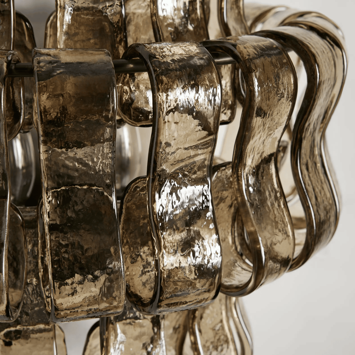 Close-up of a decorative metallic object with wavy design on a white background