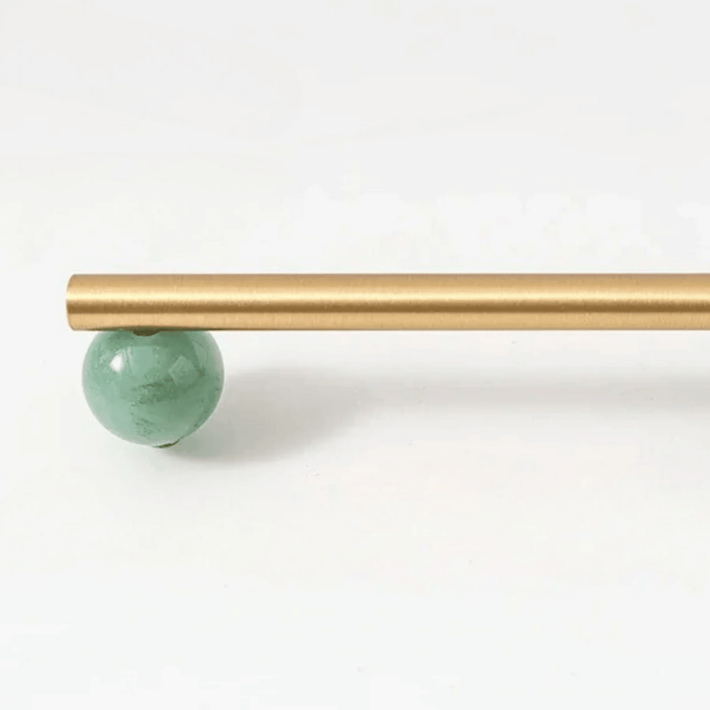 Gold rod with a green ball on a white background