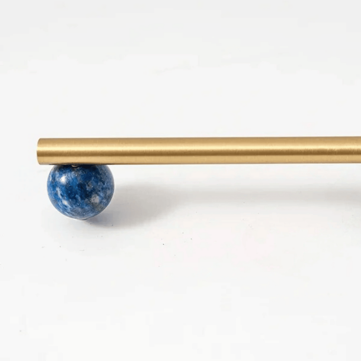 Gold rod with a blue spherical object on a white background