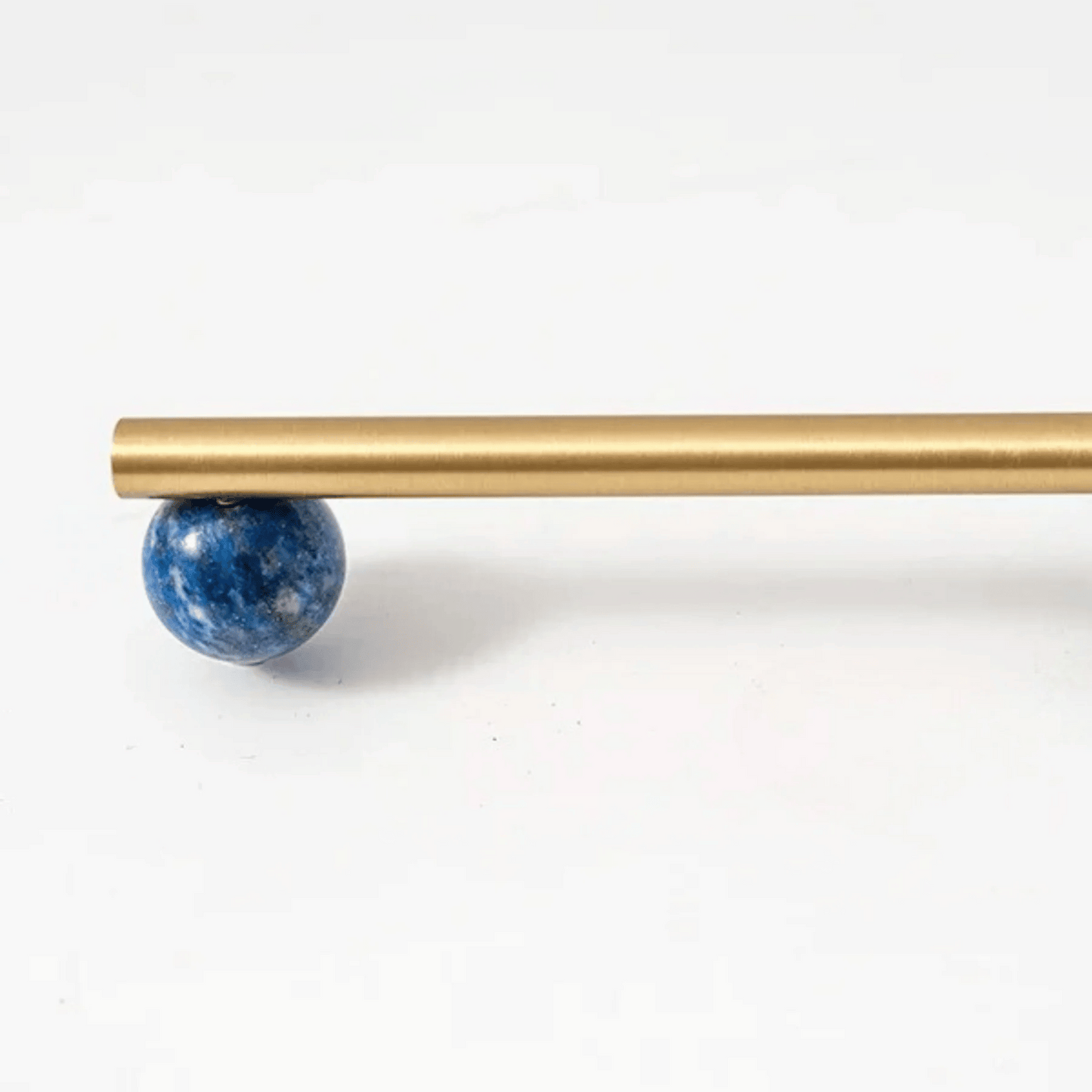 Gold rod with a blue spherical object on a white background
