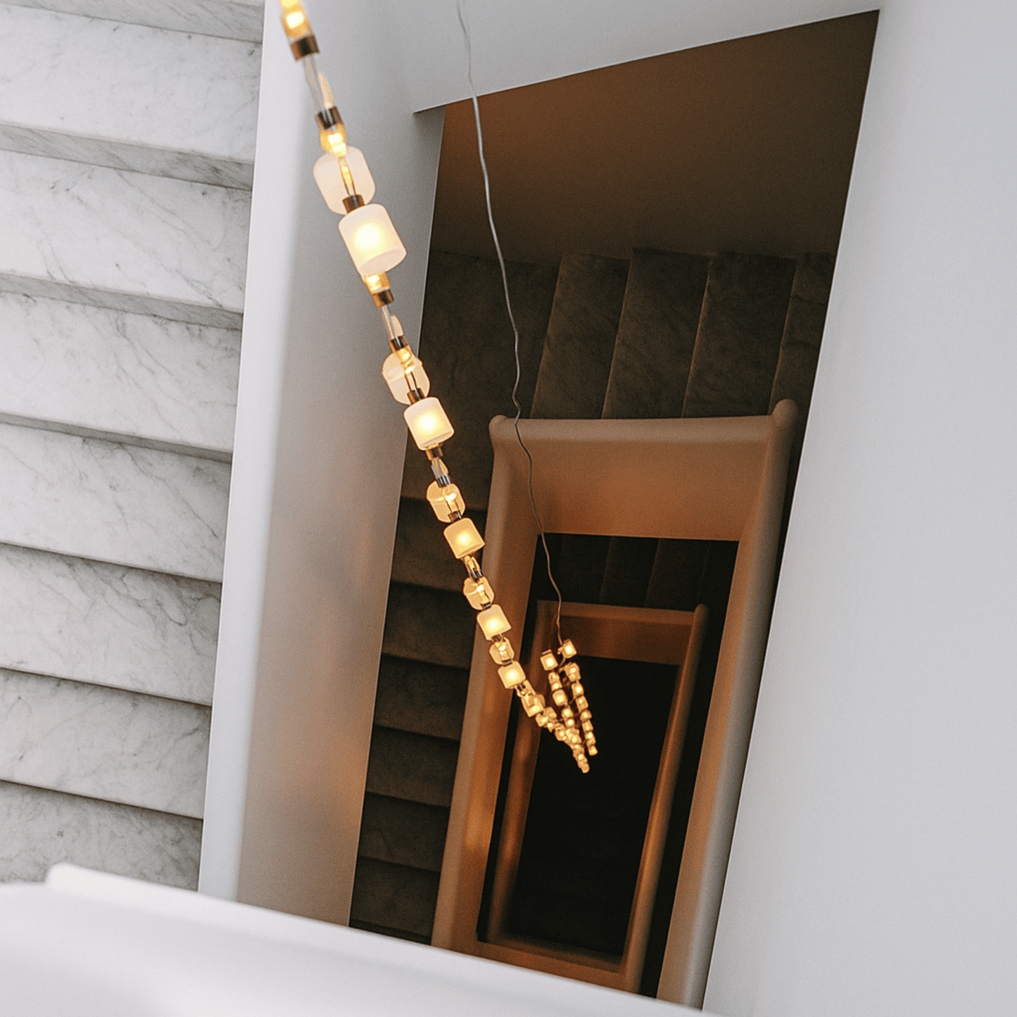 Decorative string lights hanging over a staircase with marble walls.