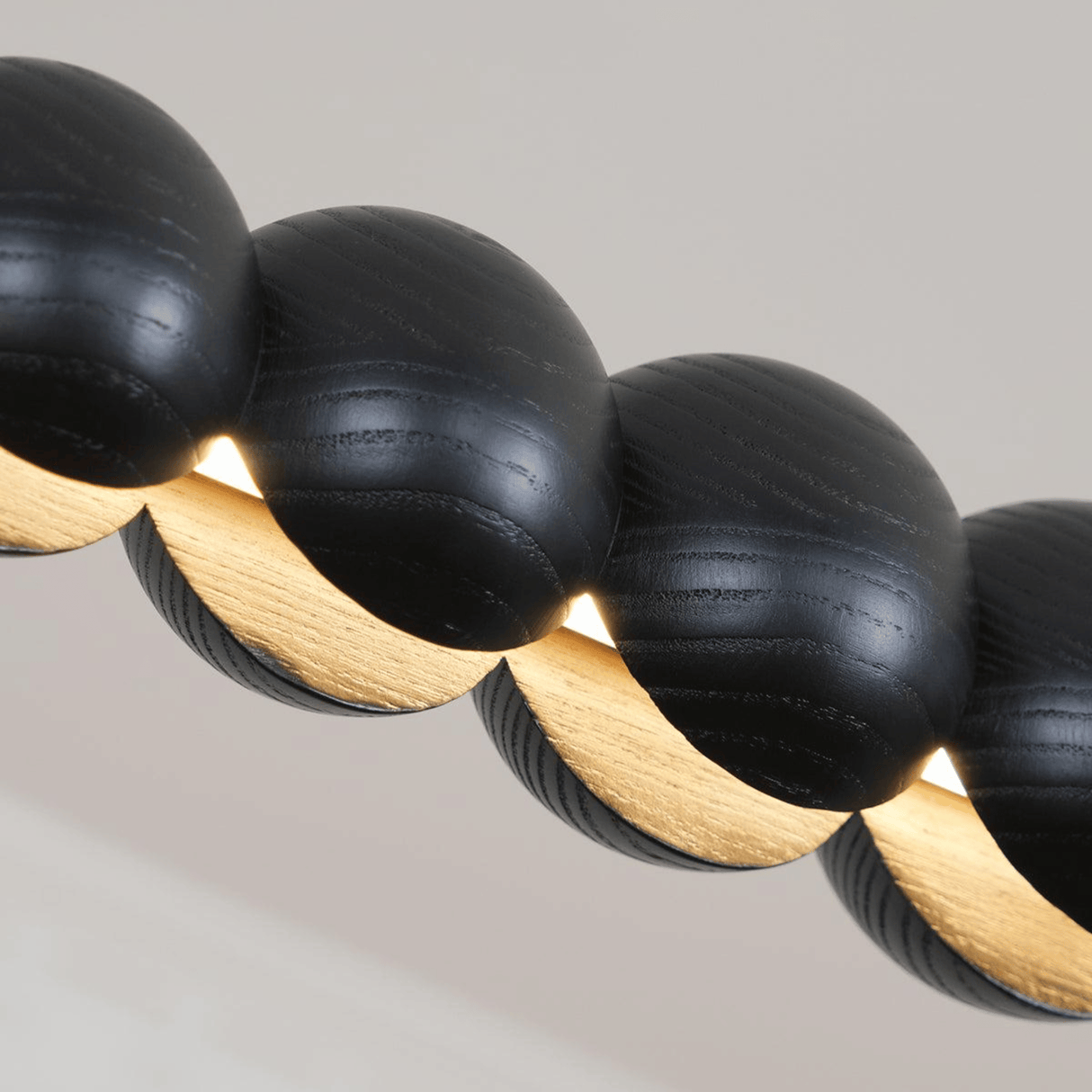 Close-up of black and gold beaded necklace on a neutral background
