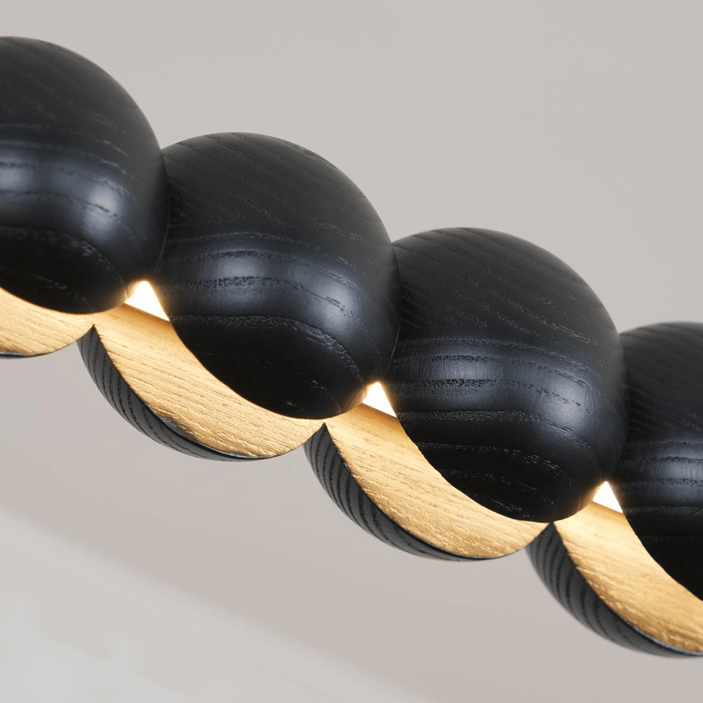 Close-up of black and gold beaded necklace on a neutral background