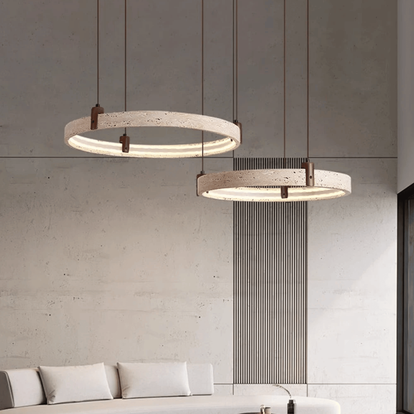 Two modern pendant lights hanging above a sofa in a living room setting.