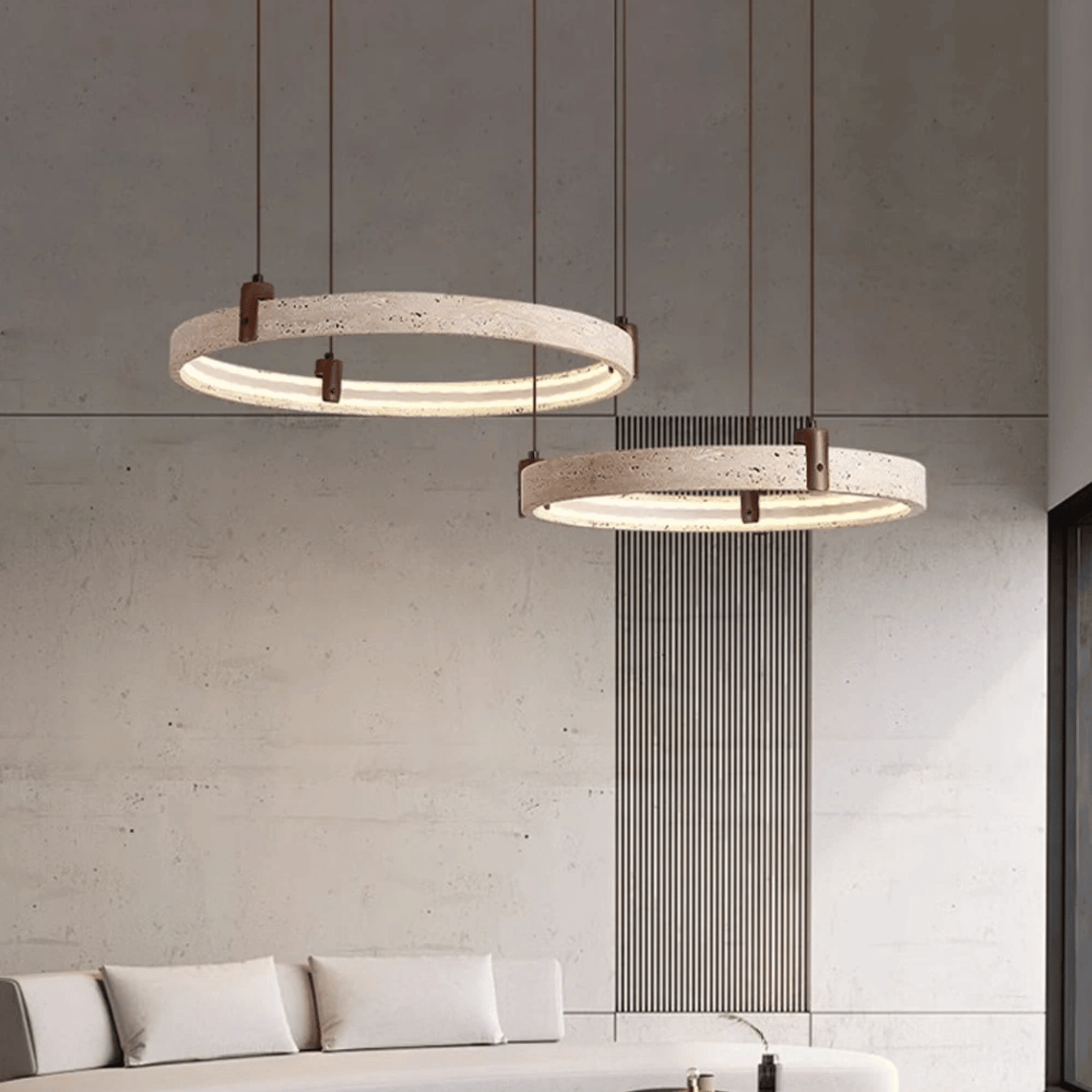 Two modern pendant lights hanging above a sofa in a living room setting.