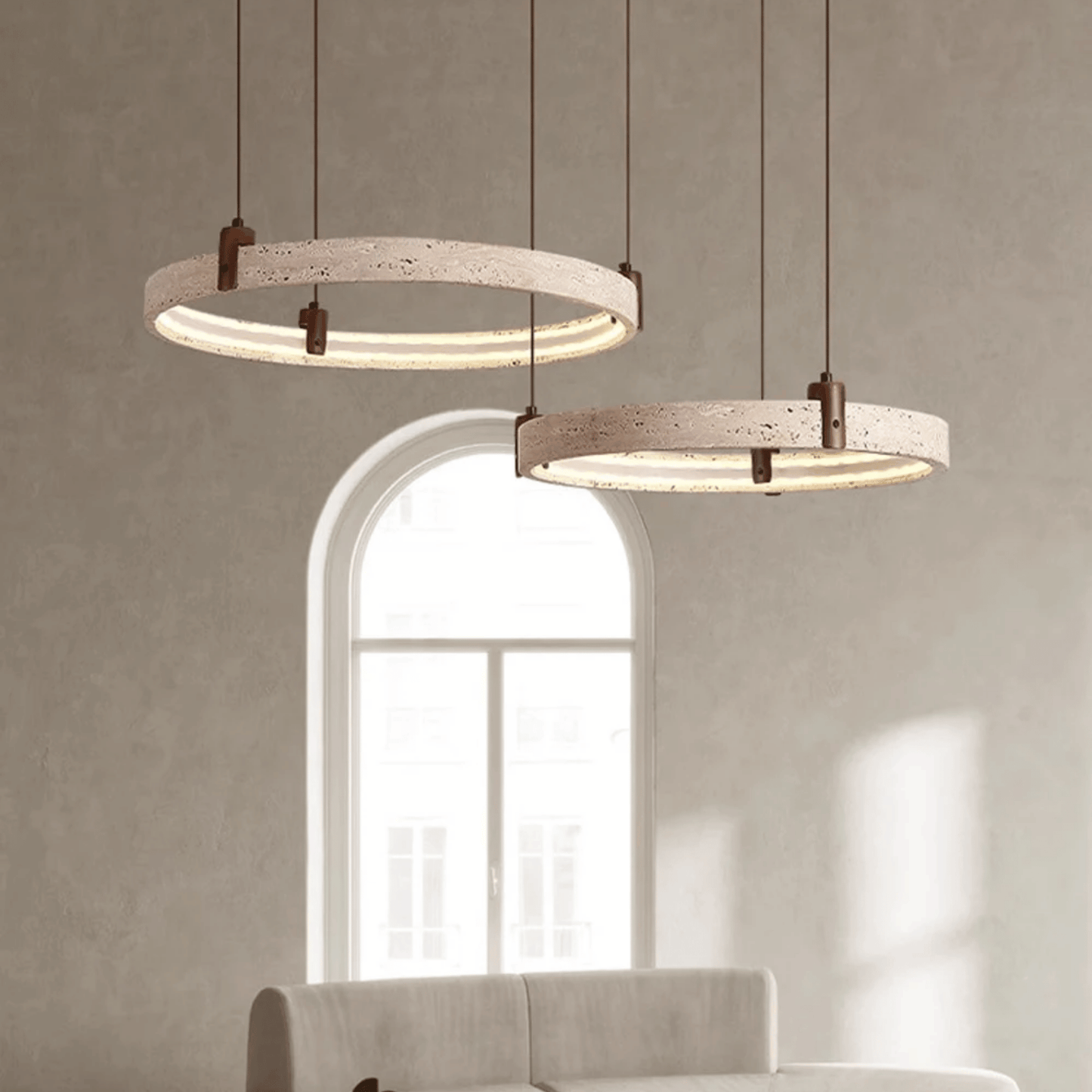Two modern pendant lights hanging in a room with a neutral color scheme.