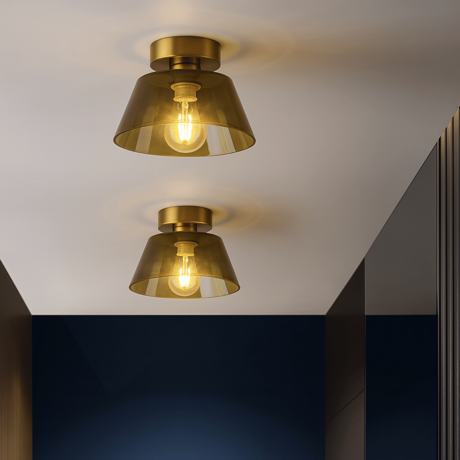 Two gold ceiling lights on a white ceiling with a dark wall background
