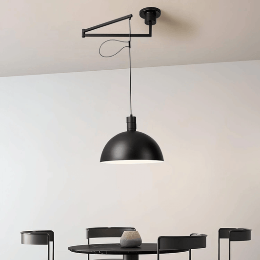 Black pendant light hanging above a dining table with a neutral background