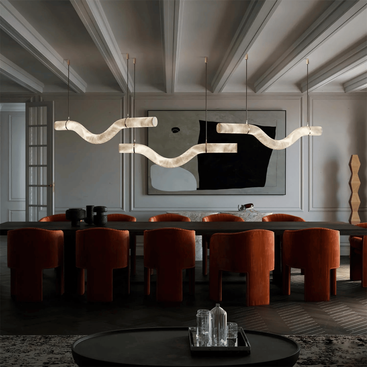 Modern dining room with a long table, chairs, and decorative wall art.