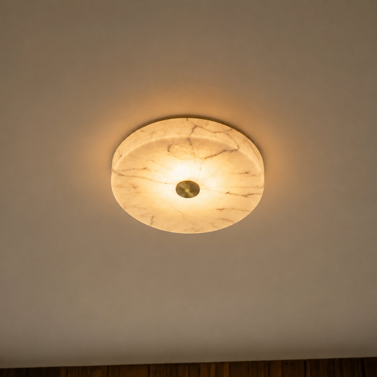 Ceiling light fixture with marble-like finish on a plain wall