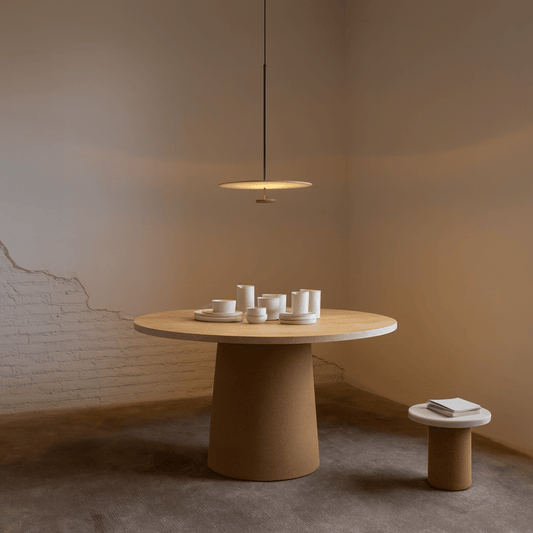 Round wooden table with a pendant light in a minimalistic room.