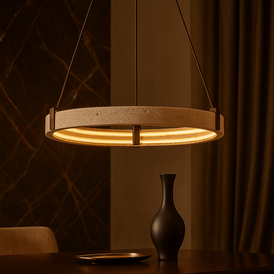 Modern pendant light hanging above a table with a vase and plate in a warm-toned room.