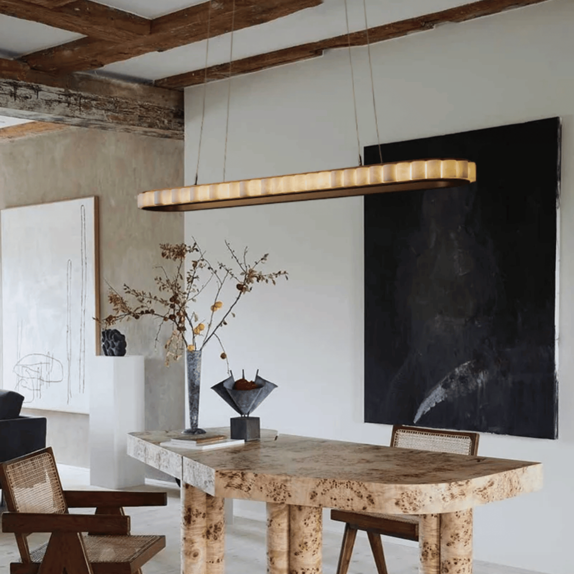 Modern dining room with wooden table, chairs, and pendant light fixture.