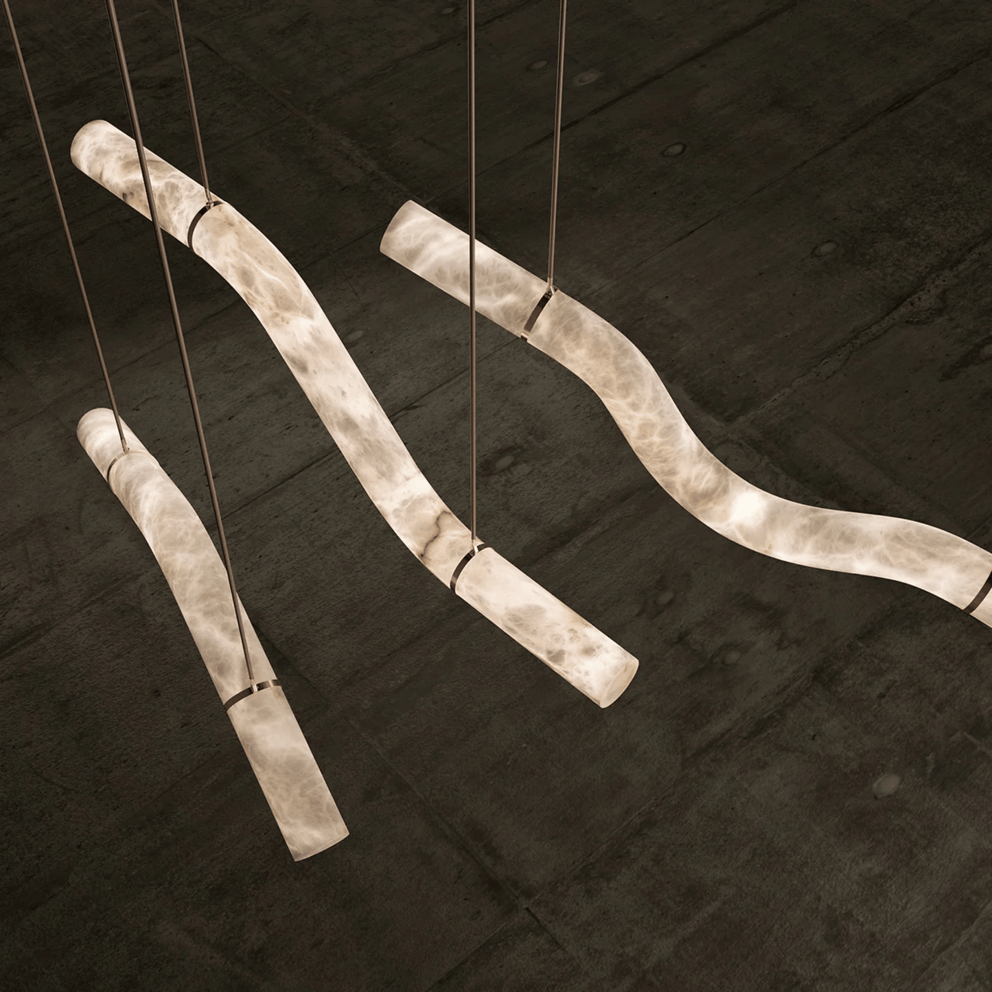 Decorative light fixture with curved metal rods on a dark wooden background