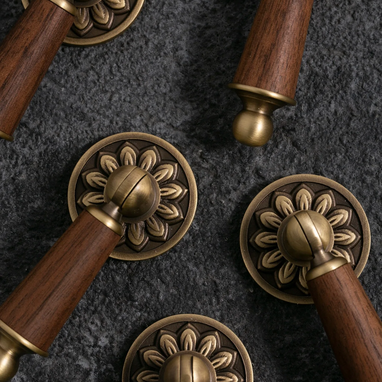 Decorative metal handles with wooden grips on a dark textured background