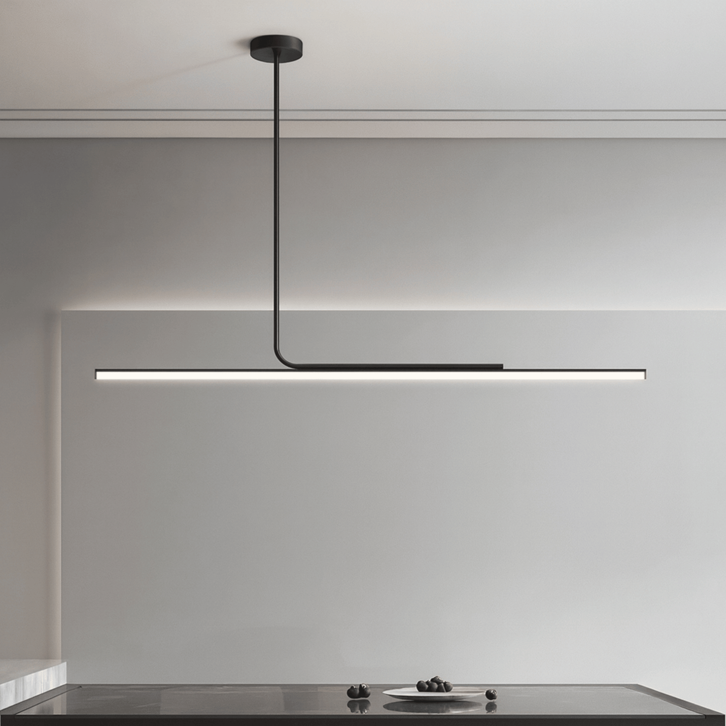 Modern pendant light hanging above a kitchen counter with a neutral background