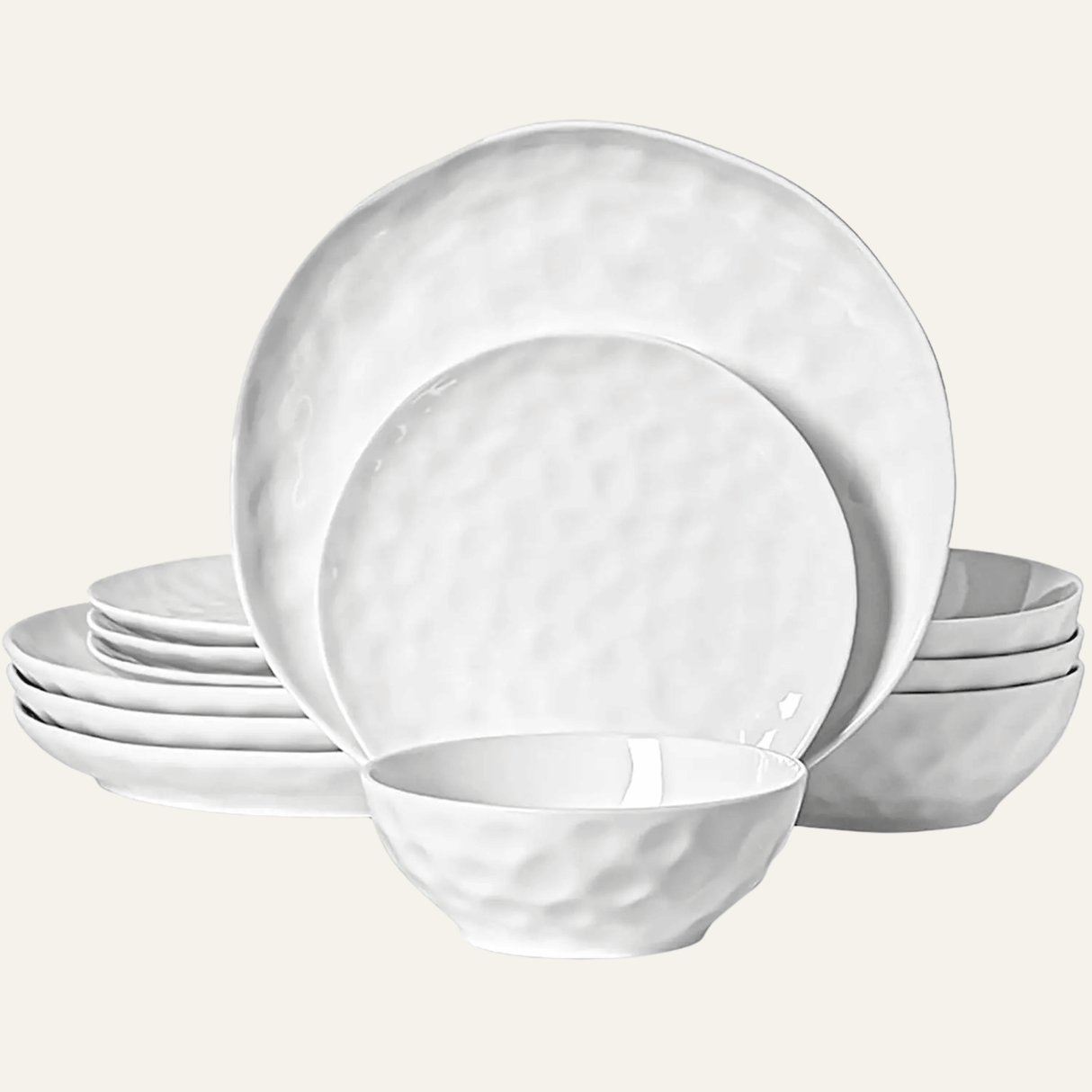 Set of white ceramic dinnerware including plates and bowls on a light gray background