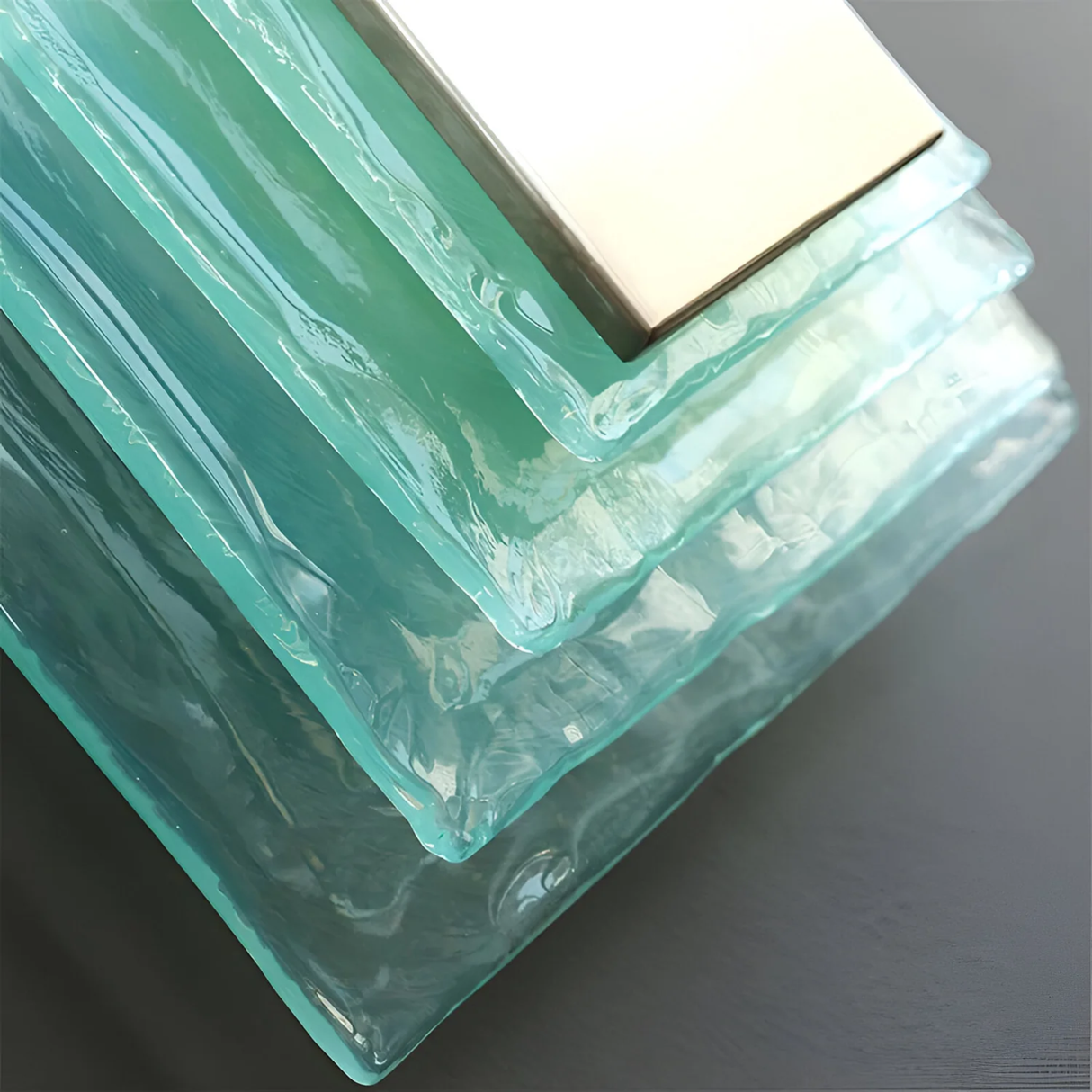 Turquoise glass block with a gold border on a dark background