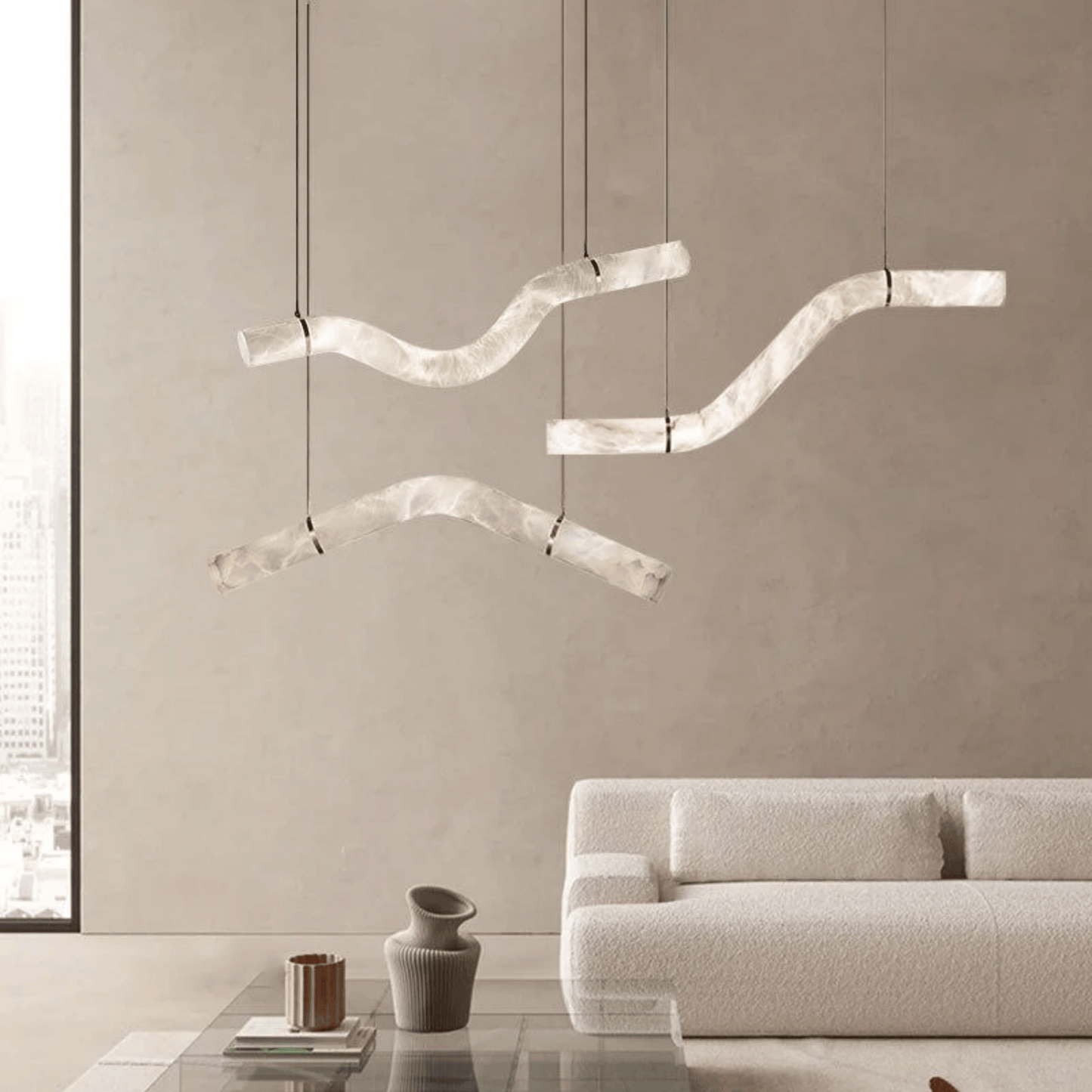 Modern pendant lights hanging above a living room with a neutral color scheme.