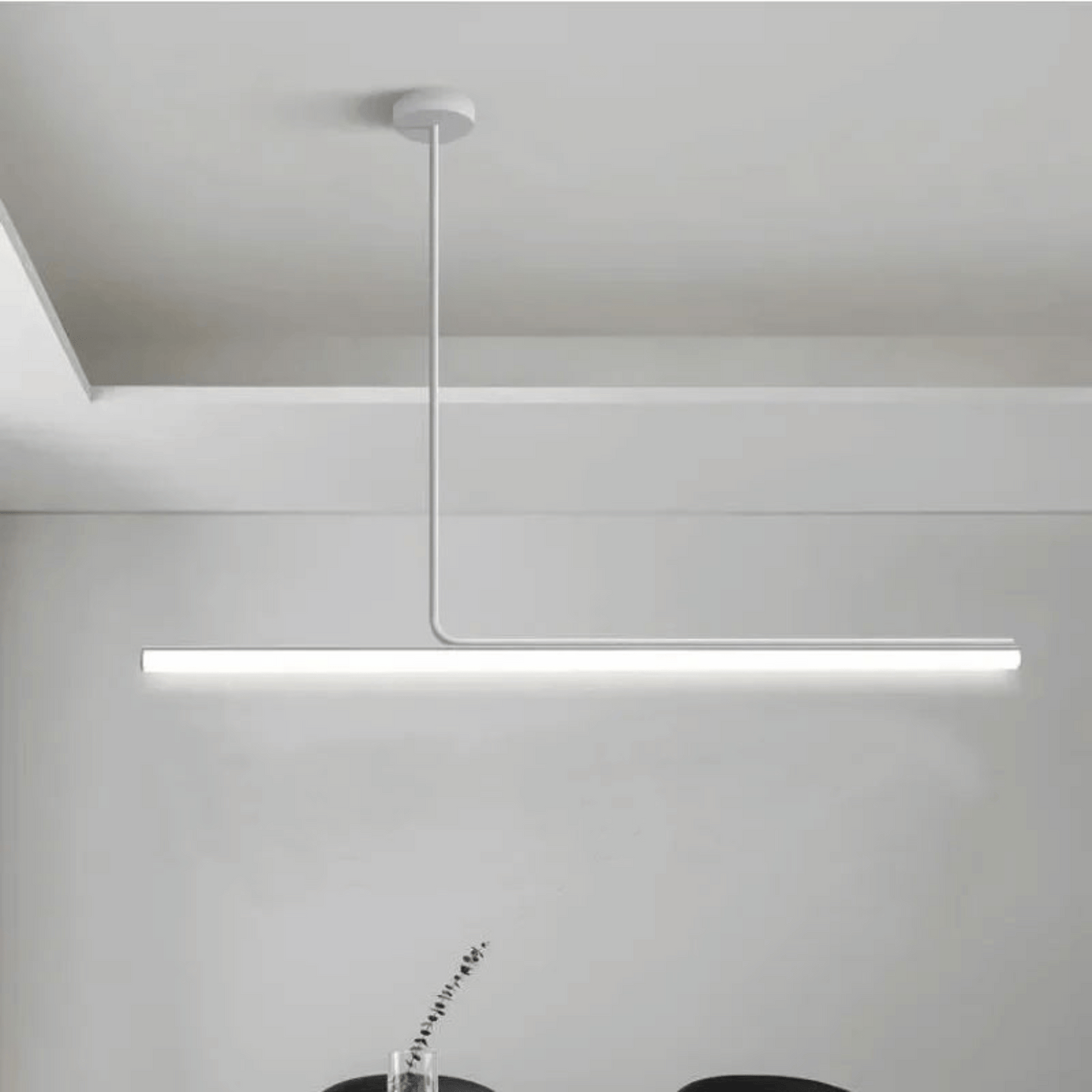 Modern pendant light hanging from a ceiling in a minimalistic setting.