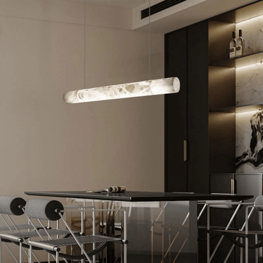 Modern pendant light hanging above a dining table in a stylish interior setting.