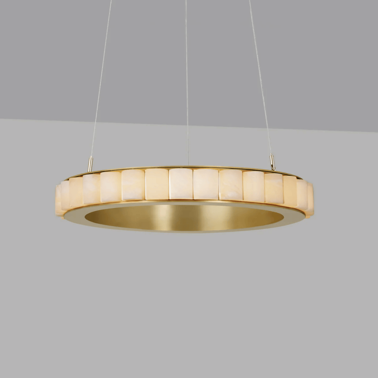 Gold pendant light fixture on a gray background