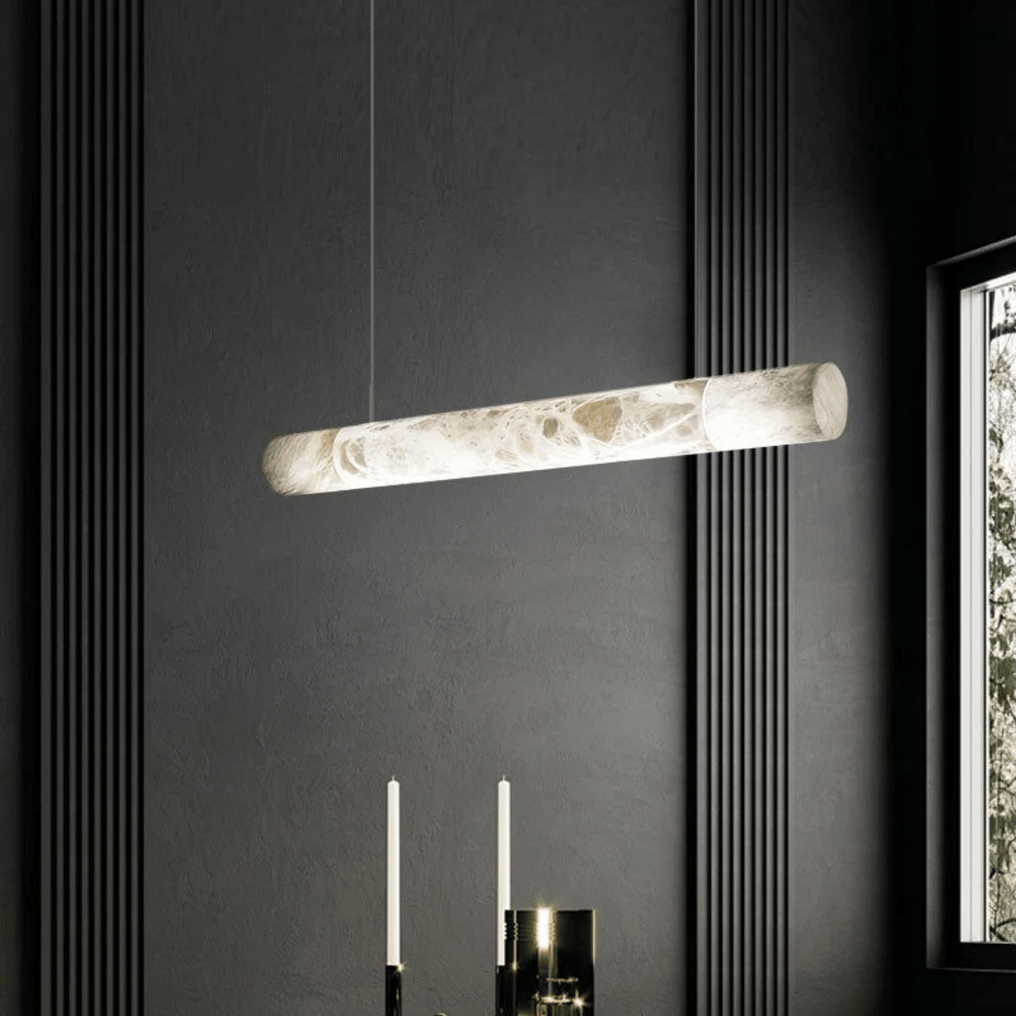 Modern pendant light fixture hanging against a dark wall with a window on the right.