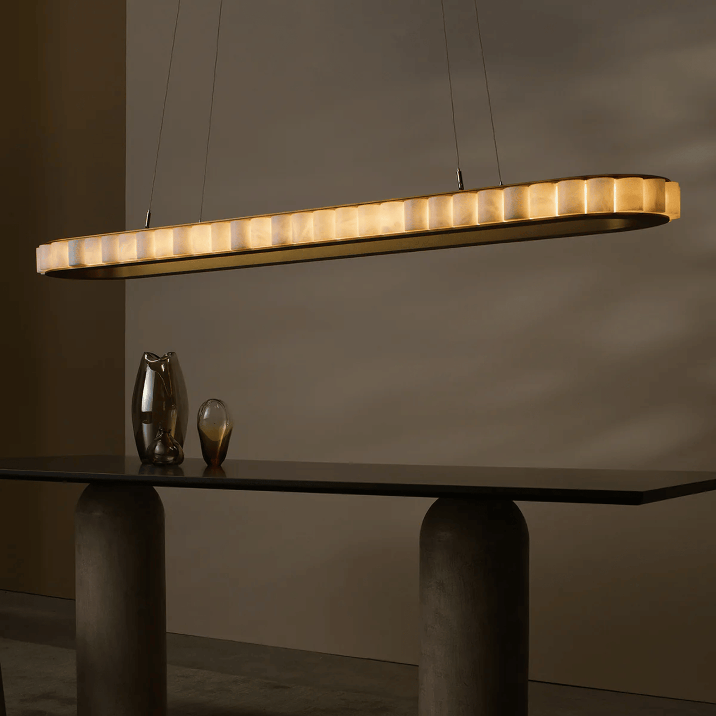 Modern pendant light hanging above a dark table with a neutral background