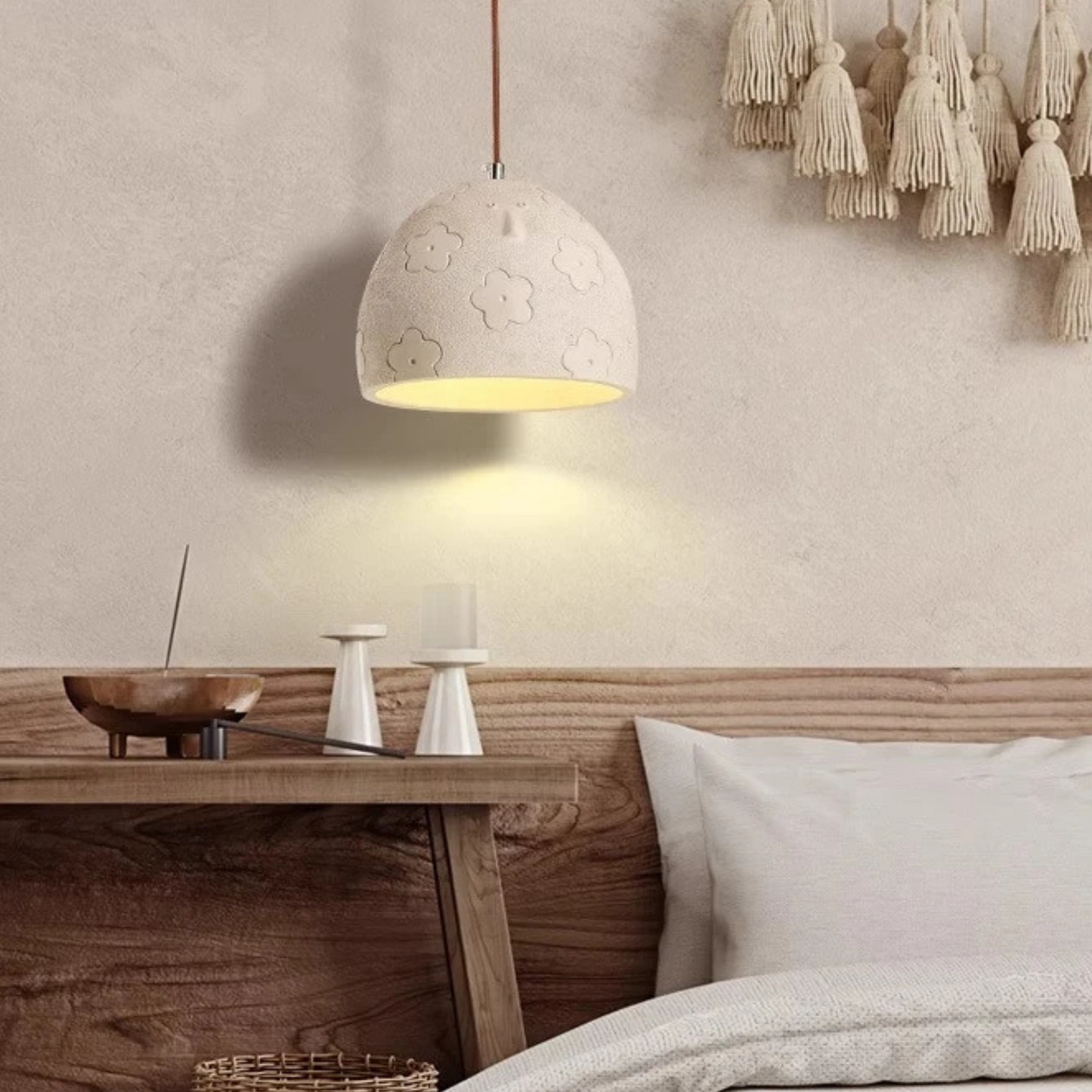 Neatly arranged room with a wooden desk, decorative lamp, and tassels on a wall.