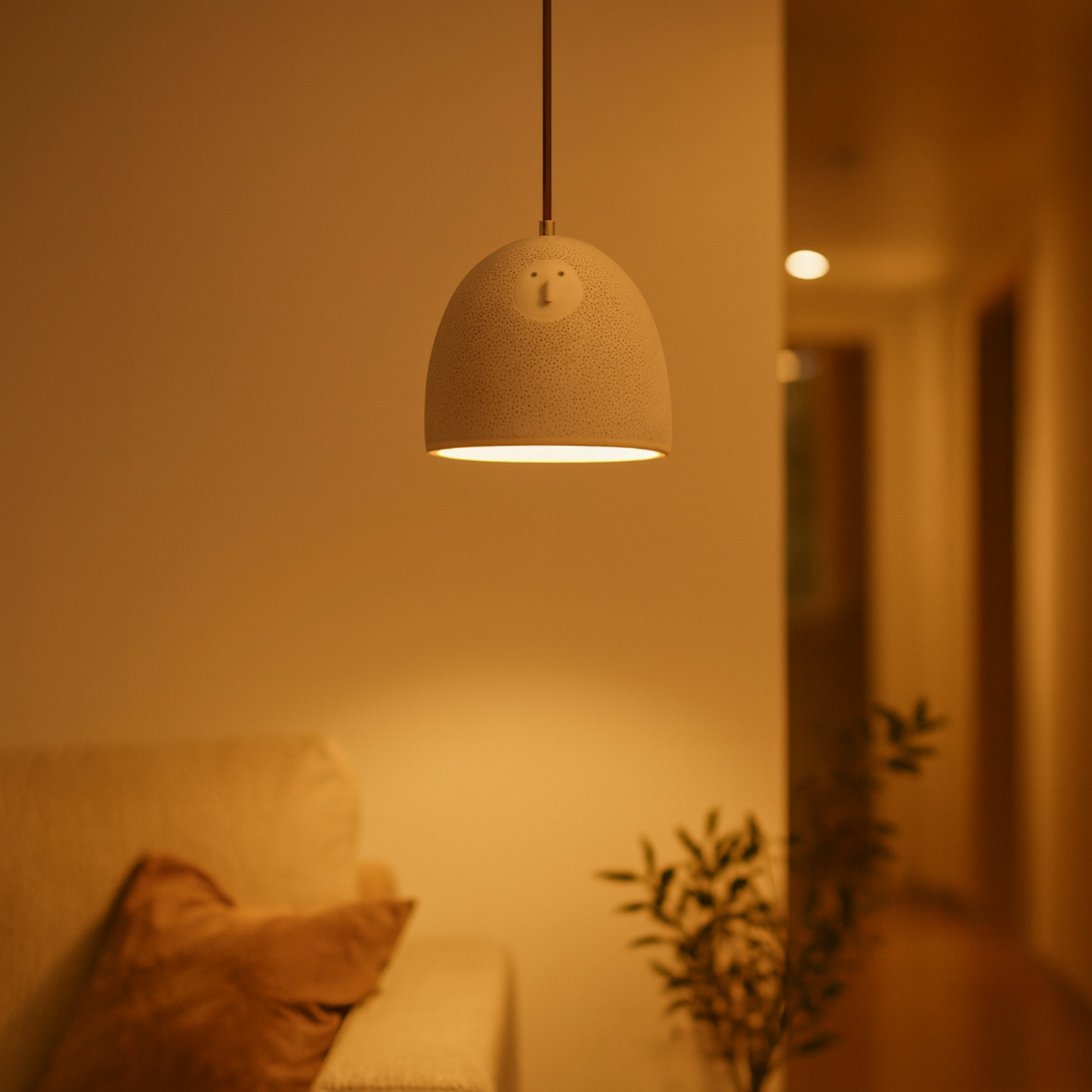 Cylindrical pendant light fixture in a softly lit room with a blurred background