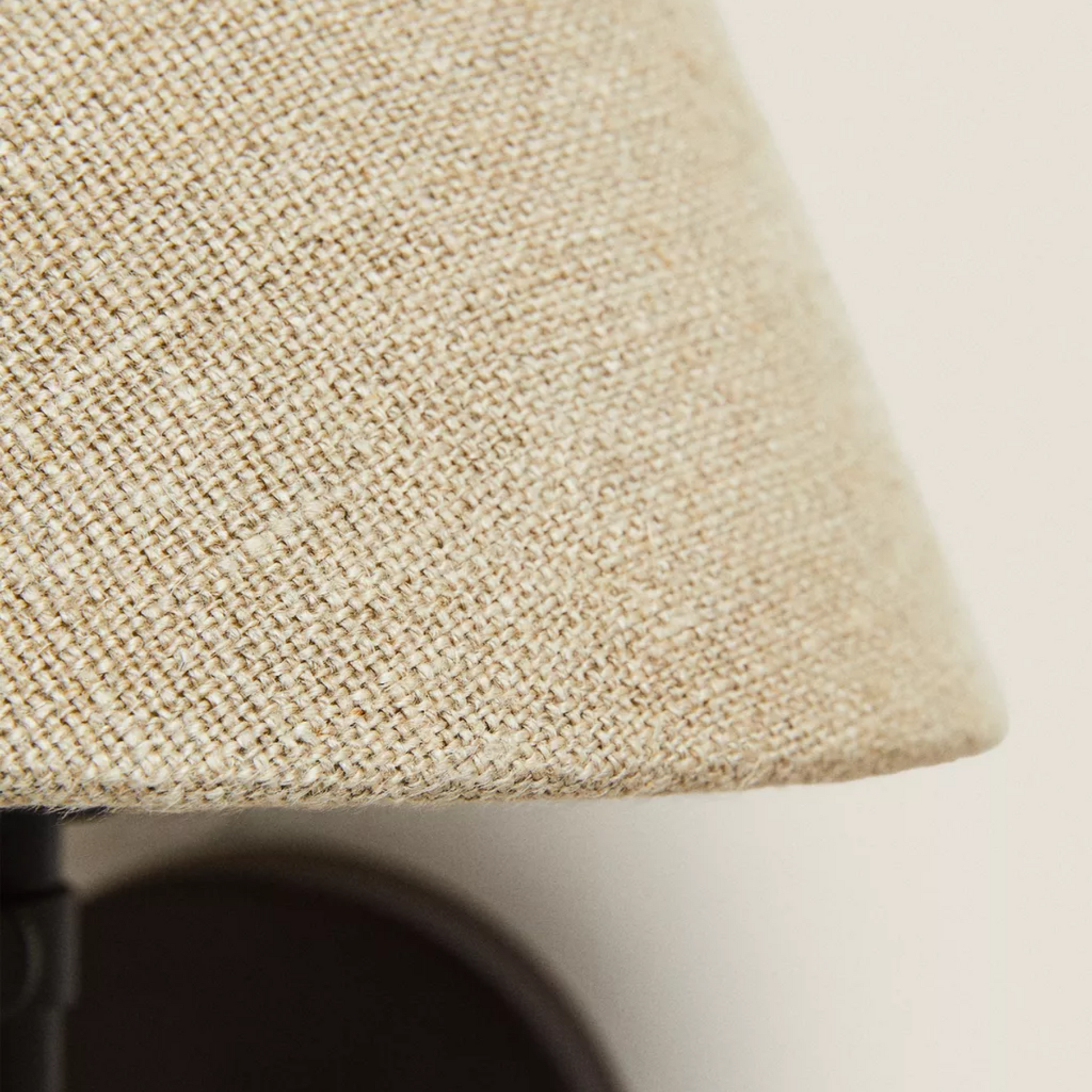 Close-up of a textured beige lampshade on a neutral background