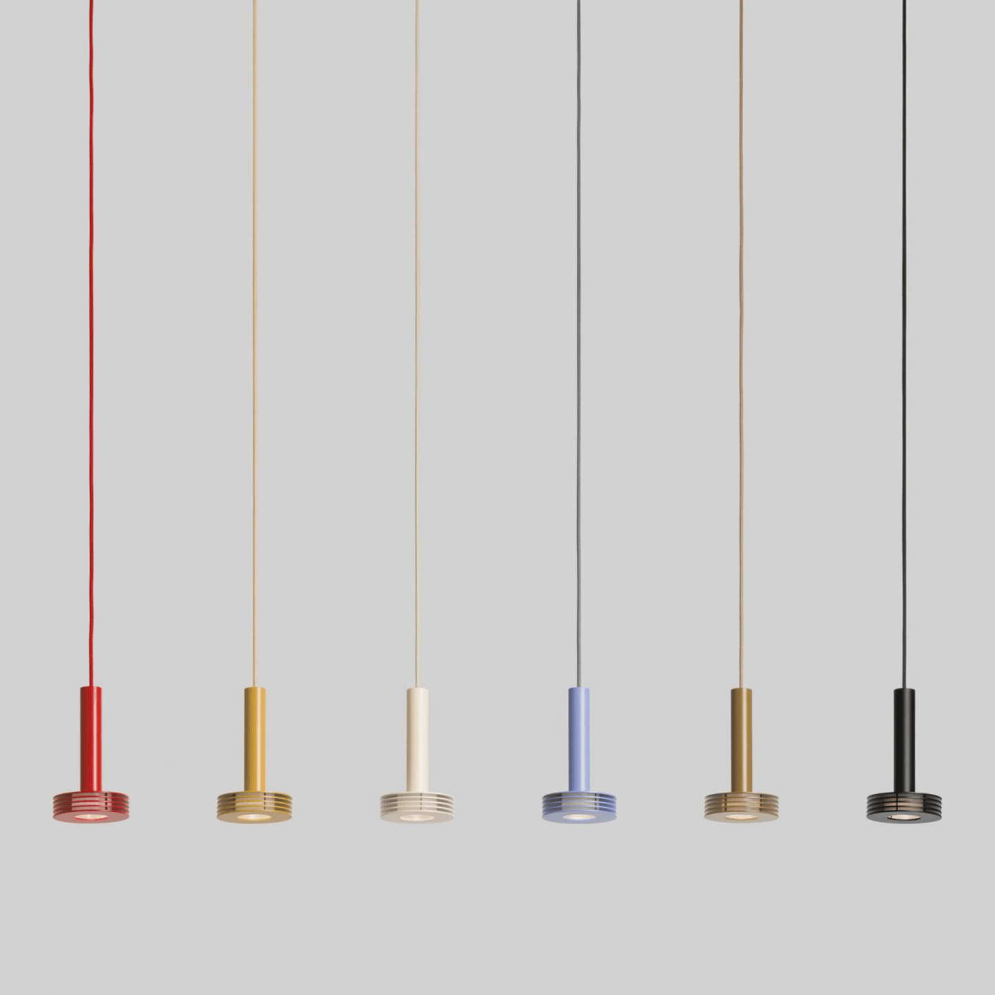 Five pendant lights in different colors hanging against a gray background