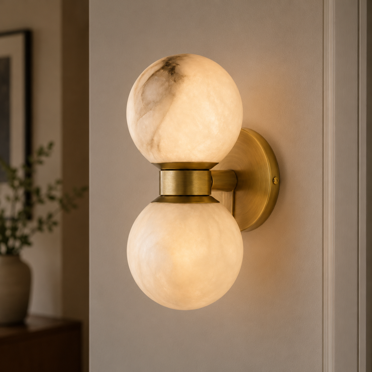 Wall-mounted light fixture with marble-like glass shades on a neutral wall.