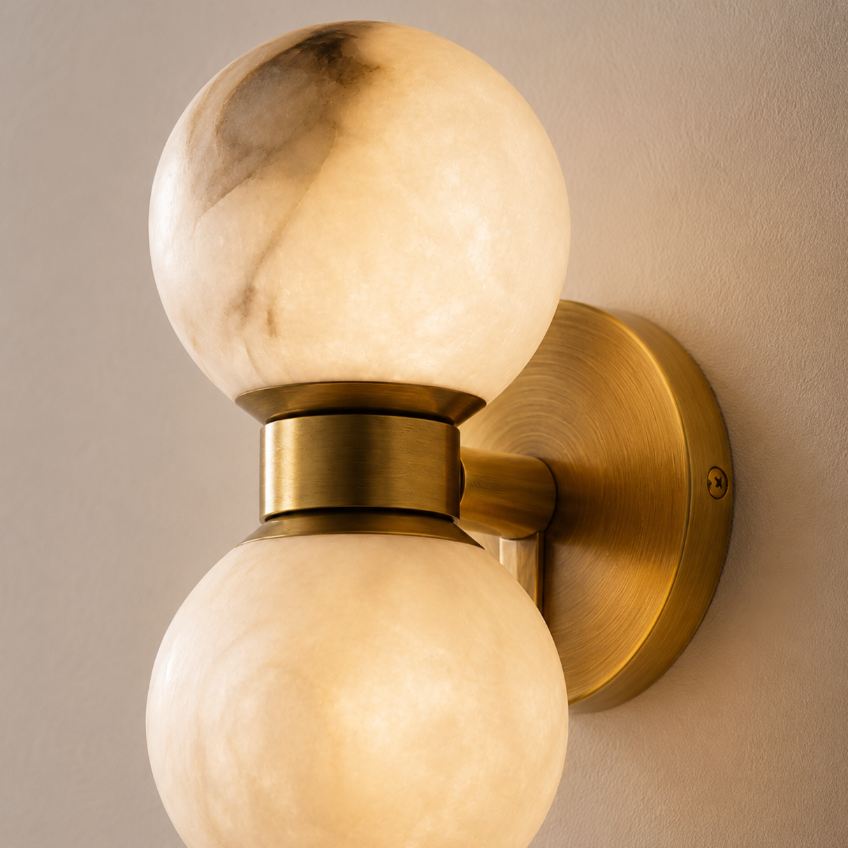 Wall-mounted light fixture with marble-like globe shades on a neutral wall.