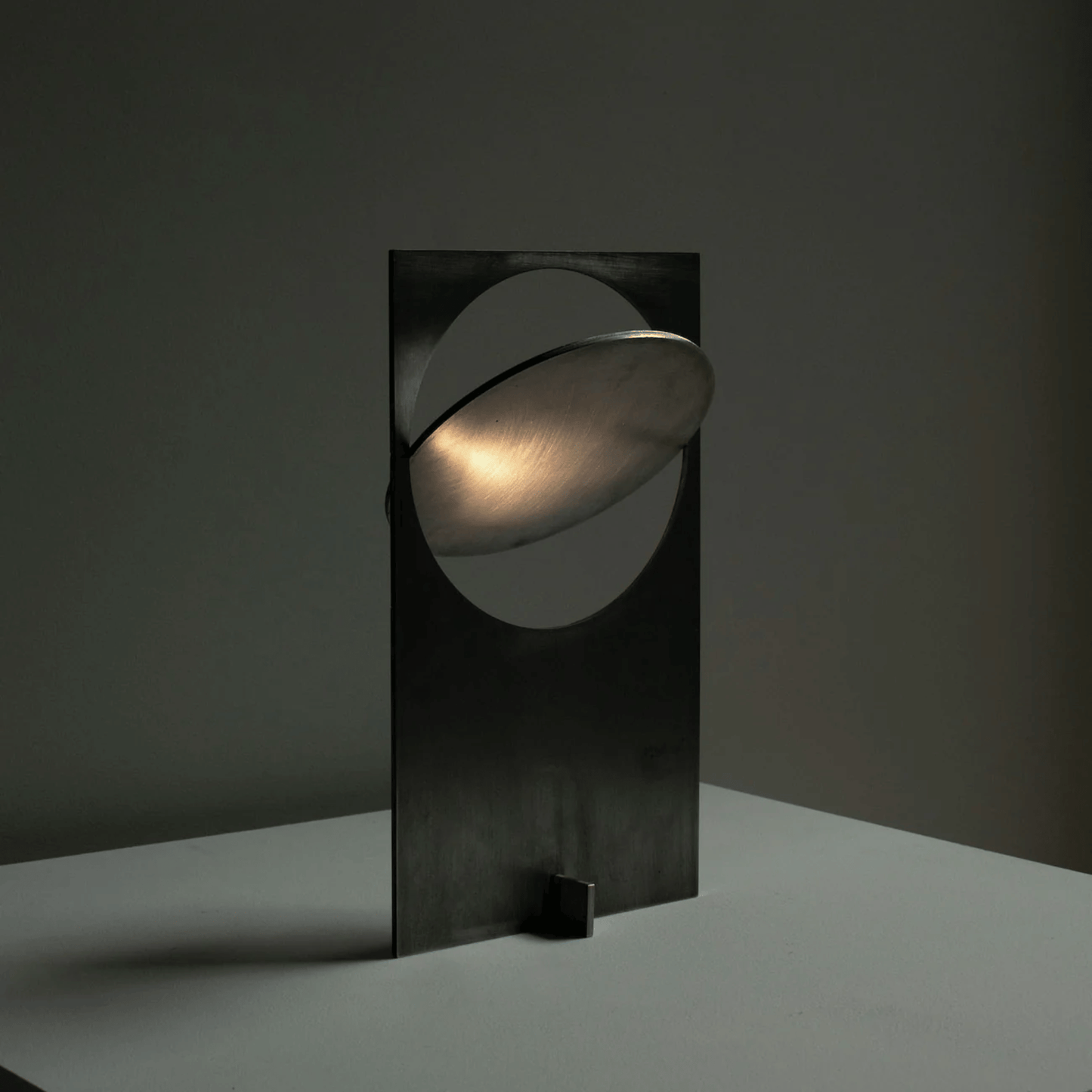 Modern black table lamp with a circular design on a dark background