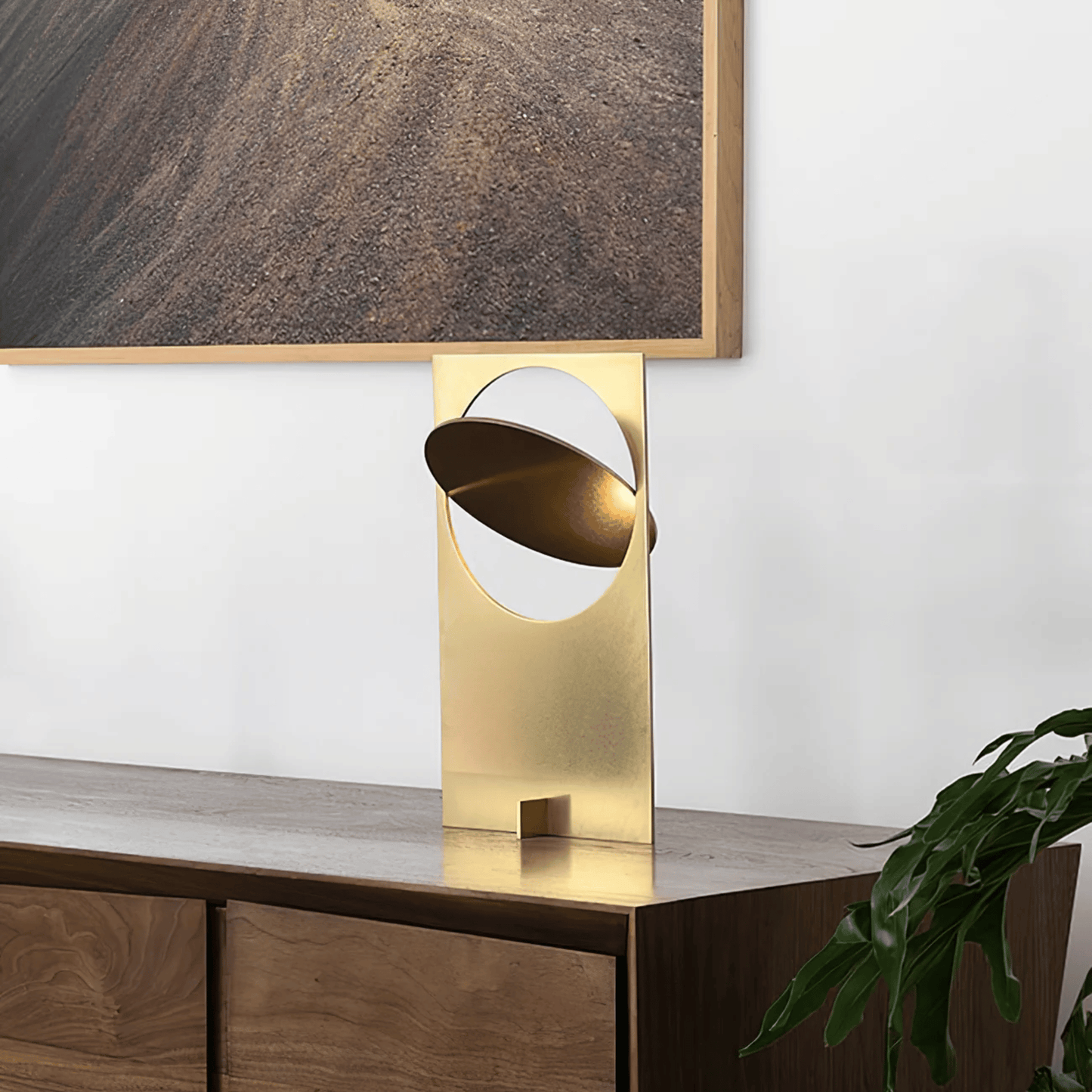 Gold table lamp on a wooden surface with a neutral background
