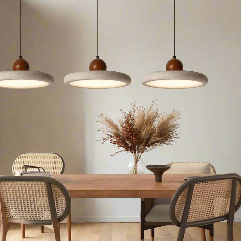 Dining area with wooden table and chairs under three pendant lights.