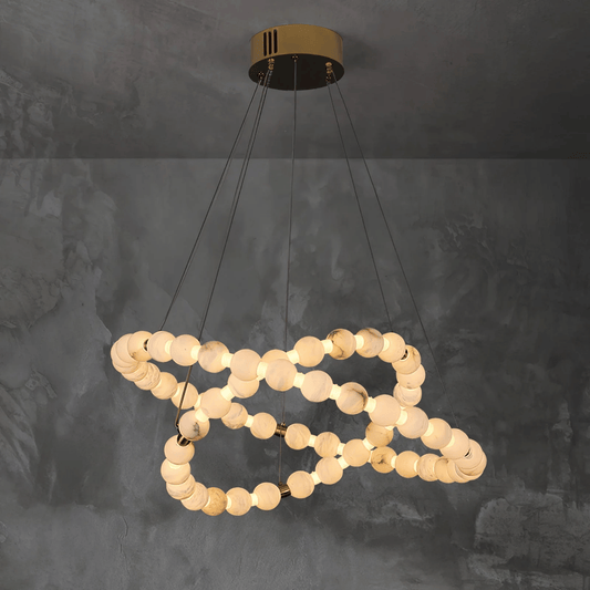Modern chandelier with circular design on a dark textured wall