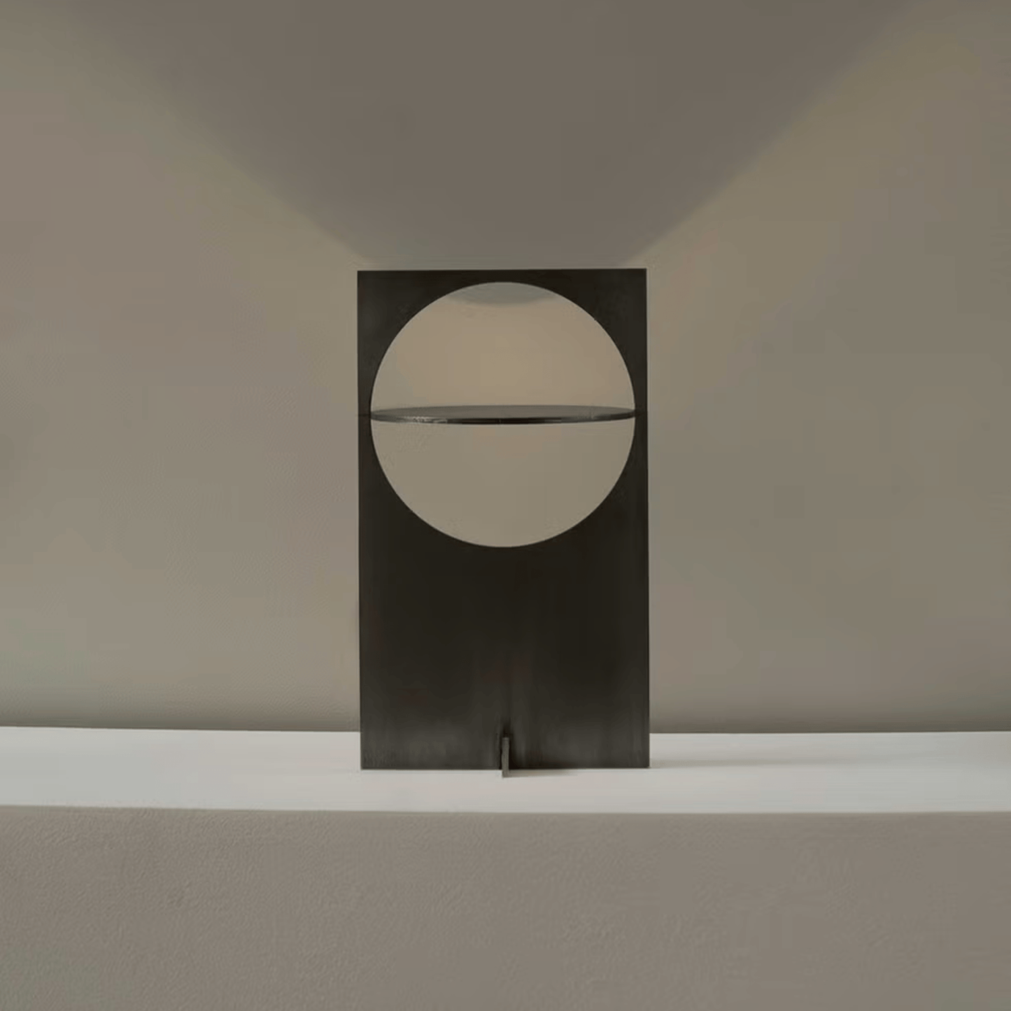 Modern wall-mounted light fixture with a circular design on a neutral background