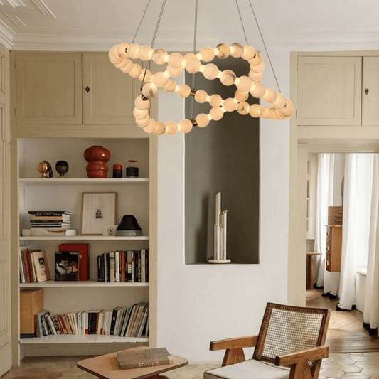Modern living room with a round pendant light, bookshelf, and wooden chair.